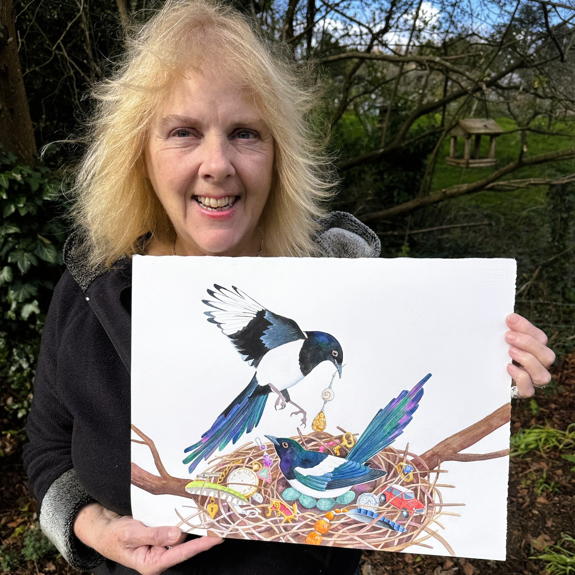 artist Jane Tomlinson with her painting of two magpies with treasure